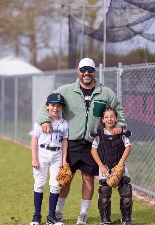 Coach Myles Berniard-Mendez with two young players